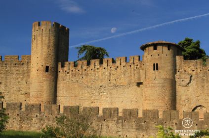 Roman and medieval ramparts, stone wall and towers from the Carcassonne Castle, blue skies and white moon.