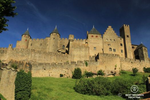 The medieval walled city of Carcassonne without people, on a hill, in the sun and with blue skies.