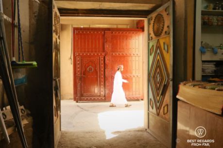 Young man walking by the souq, Nizwa, Oman