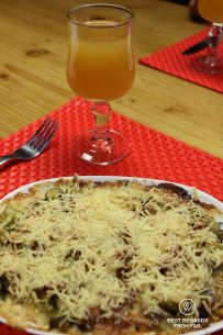 Homemade cheese and vegetable gratin with a glass of local rum at the Gîte de Bélouve on the exclusive multiday hike through the 3 cirques, Réunion Island.